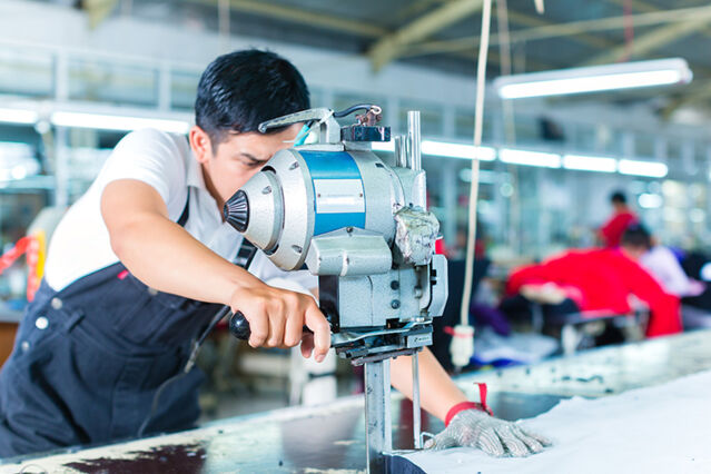 An industrial worker in overalls using precision machinery